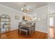 Dining room with hardwood floors, modern light fixture and adjoining kitchen with breakfast bar at 2405 N Park Ave, Indianapolis, IN 46205