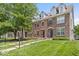 Brick townhome featuring manicured lawn, sidewalks, and tree lined streets at 2405 N Park Ave, Indianapolis, IN 46205