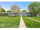 View of the property showcasing well-maintained lawn, sidewalks, and access to the garage at 2405 N Park Ave, Indianapolis, IN 46205