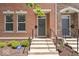 Brick townhome features entry door with concrete steps, black railings and manicured shrubs at 2405 N Park Ave, Indianapolis, IN 46205