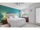 Inviting bedroom with a teal accent wall, plush bedding, and natural light at 2405 N Park Ave, Indianapolis, IN 46205