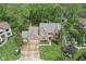 Aerial view of a brick home with a circular driveway, lush landscaping, and mature trees at 2884 Brook Vista Dr, Carmel, IN 46032