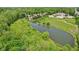 Scenic aerial view showcasing land featuring a tranquil pond surrounded by lush greenery and neighboring homes at 2884 Brook Vista Dr, Carmel, IN 46032