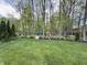 Backyard with a playhouse, playset, gravel seating area and lush green grass at 2884 Brook Vista Dr, Carmel, IN 46032