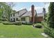 An expansive backyard with a large manicured lawn, mature trees, and a stone patio area at 2884 Brook Vista Dr, Carmel, IN 46032