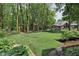 Beautifully landscaped backyard with a fire pit area, a play structure, and a serene water feature at 2884 Brook Vista Dr, Carmel, IN 46032