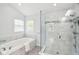 Bright bathroom featuring a soaking tub and a glass-enclosed shower with marble tile at 2884 Brook Vista Dr, Carmel, IN 46032