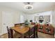 Bright dining room with wood table, modern light fixture, and view into the adjacent living space with a fireplace at 2884 Brook Vista Dr, Carmel, IN 46032