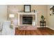 Classic brick fireplace with a white mantel, hardwood floors, and decorative accents in a cozy living room at 2884 Brook Vista Dr, Carmel, IN 46032