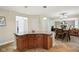 Kitchen island with granite countertop, wood cabinetry, and open view into dining and living spaces at 2884 Brook Vista Dr, Carmel, IN 46032
