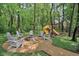 Backyard playground with a firepit area featuring Adirondack chairs, and a swing set with slide at 2884 Brook Vista Dr, Carmel, IN 46032