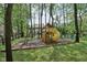 An outdoor playset with a slide and swing set nestled among the trees in the backyard at 2884 Brook Vista Dr, Carmel, IN 46032