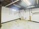 Unfinished basement displaying concrete floors, white-painted brick walls, and exposed ceiling with ductwork at 2908 Fairview St, Anderson, IN 46016