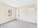 A bright bedroom features neutral walls and carpeting with one window and two doors at 2908 Fairview St, Anderson, IN 46016