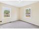 A bright bedroom features neutral walls and carpeting with two windows to allow ample light at 2908 Fairview St, Anderson, IN 46016