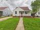 Inviting home with a classic porch, lush green lawn, and mature tree in a peaceful, suburban setting at 2908 Fairview St, Anderson, IN 46016