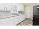 Well-lit kitchen with white cabinets, tiled backsplash, stainless steel appliances, and modern countertops at 2908 Fairview St, Anderson, IN 46016