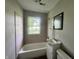 Compact bathroom featuring tiled walls, a vanity sink, toilet and a window at 3114 Adams St, Indianapolis, IN 46218
