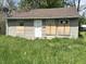 Exterior shot of a modest single-story home featuring a brown roof, boarded up windows and a simple front door at 3114 Adams St, Indianapolis, IN 46218