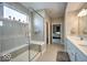 Bright bathroom with a glass-enclosed shower, built-in bench, tile walls, a double vanity with white cabinets, and a light fixture at 345 Ehrlich Ln, Westfield, IN 46074