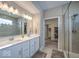 Stylish bathroom with a double sink vanity, large mirror, glass shower, modern fixtures, and an open doorway to the closet at 345 Ehrlich Ln, Westfield, IN 46074
