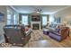 Comfortable living room featuring a fireplace, large windows, ceiling fan, and hardwood floors at 345 Ehrlich Ln, Westfield, IN 46074