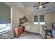 This primary bedroom features a ceiling fan, tray ceilings, a luxurious bed, and natural light from the home's windows at 345 Ehrlich Ln, Westfield, IN 46074