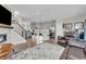 Open concept living room with a fireplace, gray kitchen, island with seating and staircase at 3546 Brampton Ln, Westfield, IN 46074