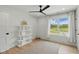 Bright bedroom boasts a ceiling fan, a neutral rug, and a large window with an expansive green view at 4078 Besbie Way, Bargersville, IN 46106