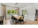Bright dining area with a wooden table, black chairs, modern lighting, and a view of the outdoor pool at 4078 Besbie Way, Bargersville, IN 46106
