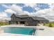 A luxurious dark colored home stands tall near a large pool in the expansive green backyard at 4078 Besbie Way, Bargersville, IN 46106