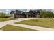 Well-manicured lawn and dark exterior of this two-story home with a three car garage and elegant landscaping at 4078 Besbie Way, Bargersville, IN 46106