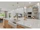 Spacious kitchen with an island with seating, a farmhouse sink, an open floor plan, and stone fireplace detail at 4078 Besbie Way, Bargersville, IN 46106