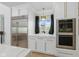 Modern kitchen with stainless steel appliances, built-in ovens, and white cabinetry with marble countertops at 4078 Besbie Way, Bargersville, IN 46106