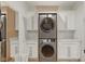 Well-equipped laundry room with a modern stacked washer and dryer and white cabinets at 4078 Besbie Way, Bargersville, IN 46106