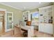 Comfortable office space with built-in shelving, a wood desk, a view of the outdoors, and light green walls at 4078 Besbie Way, Bargersville, IN 46106