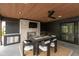 Covered outdoor living space featuring a brick fireplace, full dining set, and a built-in kitchen for upscale entertaining at 4078 Besbie Way, Bargersville, IN 46106