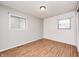 Clean and bright bedroom featuring wood flooring, neutral walls, and two windows at 423 W Janet Dr, Brownsburg, IN 46112