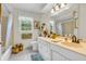 Bright bathroom with dual sinks, a window, and decorative accents at 4232 Briarwood Dr, Indianapolis, IN 46250