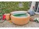 Inviting hot tub on the back patio surrounded by greenery, offering a tranquil and private spa experience at 4232 Briarwood Dr, Indianapolis, IN 46250