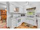 Well-lit kitchen with white cabinetry, appliances, hardwood floors, and a window over the sink at 4232 Briarwood Dr, Indianapolis, IN 46250
