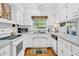 Bright kitchen featuring white cabinets, appliances, and a window overlooking the backyard at 4232 Briarwood Dr, Indianapolis, IN 46250