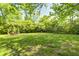 Expansive backyard with lush green lawn, mature trees, and an inviting outdoor seating area for relaxing at 4302 Kessler Blvd N Dr, Indianapolis, IN 46220