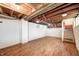 Open basement area with exposed ceiling and wooden staircase at 4302 Kessler Blvd N Dr, Indianapolis, IN 46220