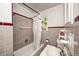 Cozy bathroom featuring a shower-tub combo, red and gray tiles, window, toilet, and sink at 4302 Kessler Blvd N Dr, Indianapolis, IN 46220