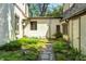 A tranquil courtyard view features stone pathways and lush greenery with stucco walls at 4302 Kessler Blvd N Dr, Indianapolis, IN 46220