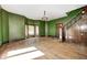 An empty living room showcasing refinished hardwood floors, fresh paint and original staircase at 4302 Kessler Blvd N Dr, Indianapolis, IN 46220