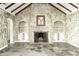 Living room displays high ceilings, stone floors, a fireplace, and two built-in shelf areas at 4302 Kessler Blvd N Dr, Indianapolis, IN 46220