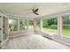 Cozy sun room with a ceiling fan and many windows that look out into the backyard at 4351 W Fox Ridge Ave, Greenwood, IN 46143