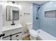 Bathroom boasts blue tiled shower, modern vanity and fixtures and updated toilet at 444 Buffalo Dr, Indianapolis, IN 46217